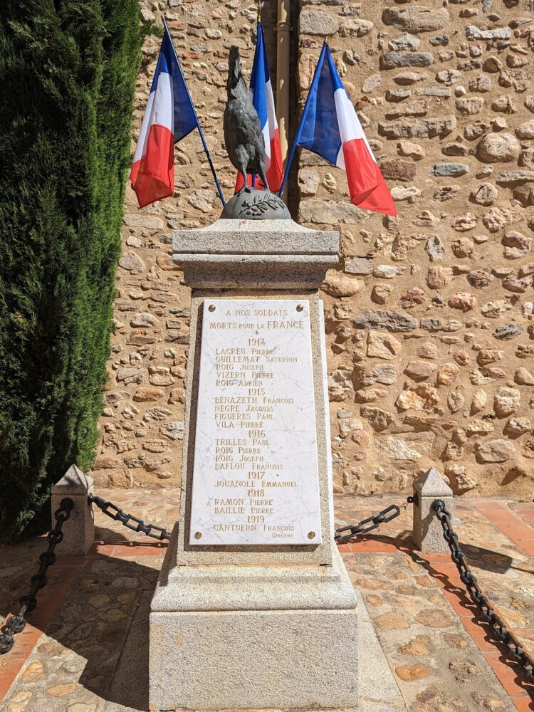 Le monument aux morts de Tresserre pavoisé.